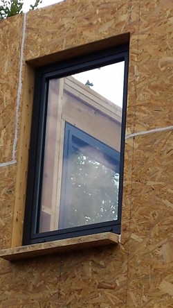 Aluminiumfenster installiert auf hölzerne Struktur.